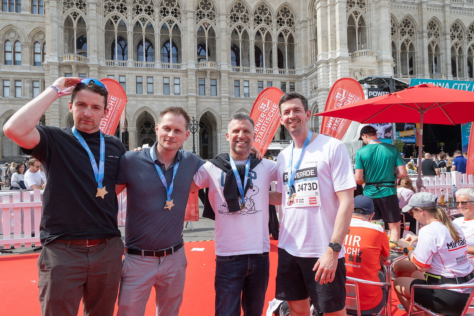 Four Nordics colleagues with medals at Vienna City Marathon 2026.